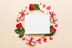 Frame made of rose, git box, heart and blank greeting card on Colored background. Top view, flat lay, copy space Holiday, Mothers Day, birthday concept photo