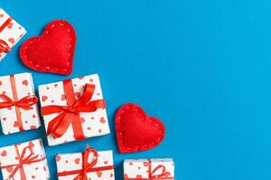 Holiday composition of giftboxes and red textile hearts colorful background with empty space for your design. Top view of Valentine's Day concept photo