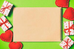 Top view of craft notebook surrounded with gift boxes photo