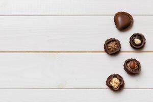 Different kinds of chocolates on colored table close-up. Top and Flat Lay with copy space photo
