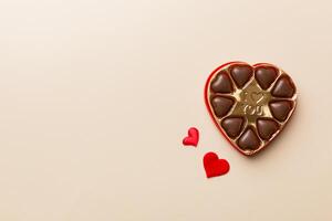 Delicious chocolate pralines in red box for Valentine Day. shaped box of chocolates top view with copy space photo