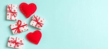 Holiday composition of gift boxes and red textile on colorful background with empty space for your design. Top view of Valentine's Day concept photo