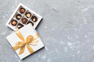 White box with chocolates candies and golden . top view with copy space photo