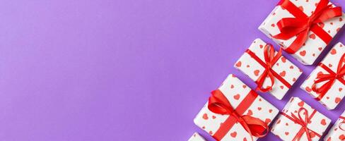 Holiday composition gift boxes with red hearts on colorful background with empty space for your design. Top view of Valentine's Day concept photo