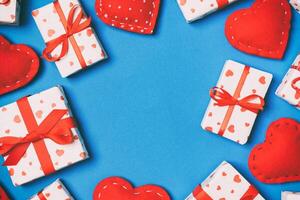 Top view of festive gift boxes and red textile hearts on background with copy space. St Valentine's day concept photo