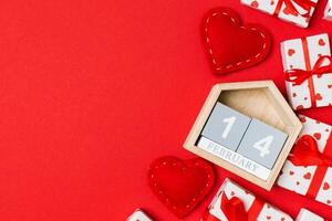 Top view of gift boxes, wooden and red textile hearts on colorful background. The fourteenth of february. St Valentine's day concept with copy space photo