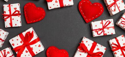 Top view of festive gift boxes and red hearts on colorful background with copy space. St Valentine's day concept photo