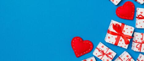 Top view gift boxes and red textile hearts on colorful background with copy space. St Valentine's day concept photo