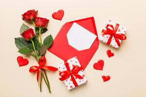 Valentine day composition with Envelope rose flower and Red heart on table. Top view, flat lay. Holiday concept photo