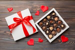 Delicious chocolate pralines in red box for Valentine Day. Heart shaped box of chocolates top view with copy space photo