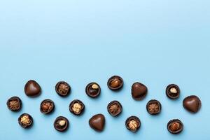 Different kinds of chocolates on colored table close. Top View and Flat Lay with copy space photo