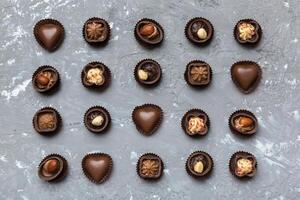 Different kinds of chocolates on colored table close. Top View and Flat Lay photo