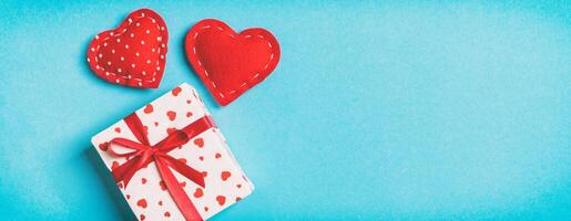 Holiday composition of gift boxes and red textile heart on colorful background with empty space for your design. Top view of Valentine's Day concept photo