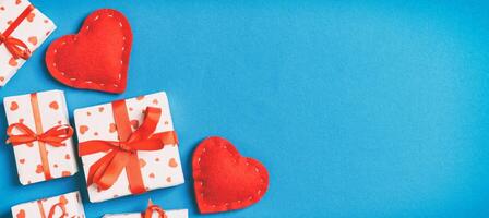 Holiday composition of gift boxes red textile hearts on colorful background with empty space for your design. Top view of Valentine's Day concept photo