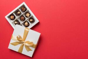 White box chocolates candies and golden tape. top view with copy space photo