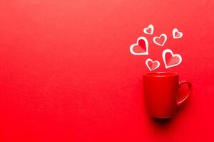 red cup on colored background, splashes red little hearts, top view with copy space photo
