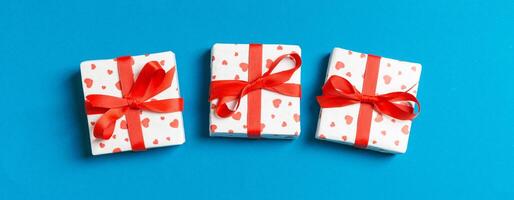 Holiday composition of gift boxes with red hearts on background with empty space for your design. Top view of Valentine's Day concept photo
