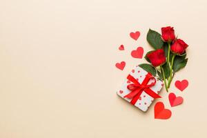 Valentine day composition with rose flower, red heart gift boxes on table. mother day and birthday greeting, copy space, top view photo