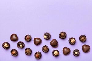 Different kinds chocolates on colored table close-up. Top View and Flat Lay with copy space photo