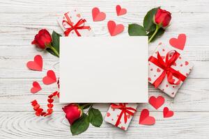 Frame made of rose, git box, heart and blank card mockup on Colored background. Top view, flat lay, copy space Holiday, Mothers Day, birthday concept photo