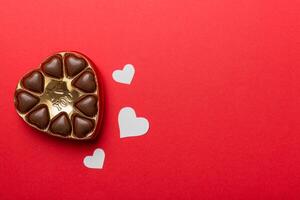 Delicious chocolate red box for Valentine Day. Heart shaped box of chocolates top view with copy space photo