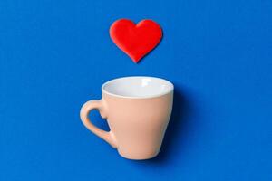 Holiday composition red hearts falling out from a cup on colorful background. Top view of Saint Valentine's Day concept with copy space photo