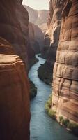 A detailed vertical shot of a river winding through a narrow canyon, with textured rock walls and ample space for text. photo