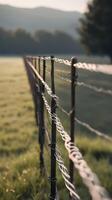 A simple vertical shot of a wire fence with a soft focus, featuring plenty of negative space in the background. photo
