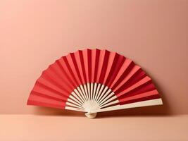 A refined red paper fan set against a soft, neutral cream backdrop, leaving plenty of room for text or a logo. photo