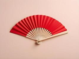 A delicate red paper fan placed on a light cream background, providing a simple, elegant design with space for text or a logo. photo