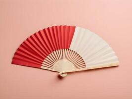 A sleek red paper fan on a soft cream background, designed with minimal detail and ample space for branding or text. photo
