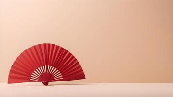 A simple red paper fan positioned against a soft cream background, with minimal detail and space for a brand logo or text. photo
