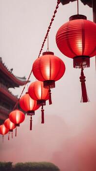 A tranquil image of red lanterns hanging gently in the air with a soft, out-of-focus backdrop, perfect for adding text below. photo