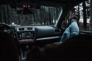 Car Interior with Modern Dashboard and Forest View Through Windshield photo
