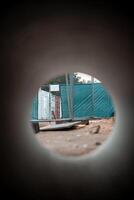View Through Circular Pipe Framing a Construction Site with Trees photo