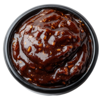 Rich and savory chocolate sauce in a black container with nuts on top, delicious and tempting for desserts and snacks isolated on transparent background png
