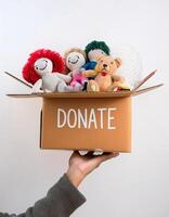 Supporting Others, Open Donation Box with Toy on Clean White Backdrop photo