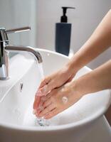 Personal Care. Close-Up of Womans Hands Washing in Bathroom Sink photo