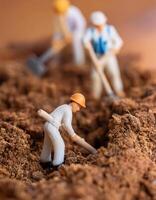 Miniature workers are diligently digging the ground photo
