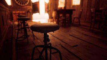 Rustic wooden stools in a vintage saloon setting during golden hour video
