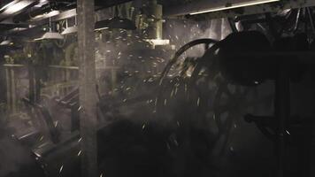 Machinery operates in a dimly lit industrial environment creating sparks video