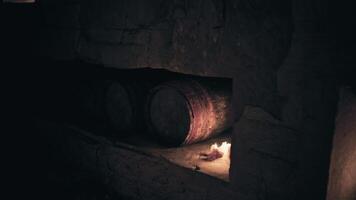 Old barrels resting in a dimly lit cellar with flickering flame video