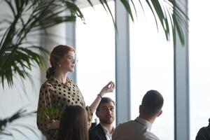 A diverse group of business professionals sits attentively in a modern office, actively participating in a training session led by an instructor, focusing on the latest technological advancements in photo