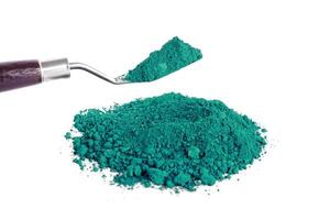 Vibrant Green Pigment Piled Next to a Scoop on a White Background photo