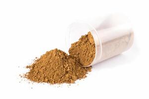 Turmeric Powder on a White Surface With a Utensil for Scooping photo