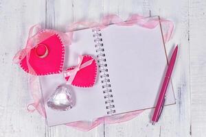 Valentines day toy hearts and notepad for your text. Top view on wooden table. photo