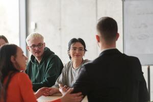 A diverse multiethnic business team engages in a collaborative meeting, discussing strategies and solutions in a modern office setting photo