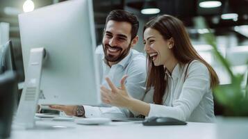 Smiling colleagues looking at computer screen in office photo