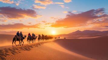 Camel Caravan Crossing a Desert Under a Sunset Sky photo