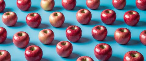 Fresh red apples arranged on a vibrant blue background symbolizing innovative agricultural practices and premium quality produce. photo